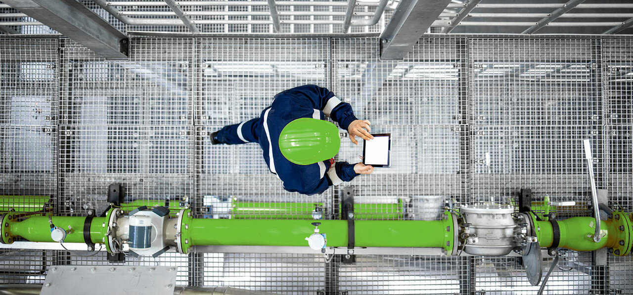 Raffineriearbeiter, der an Gasleitungen vorbeigeht und die Produktionsanlage überprüft.